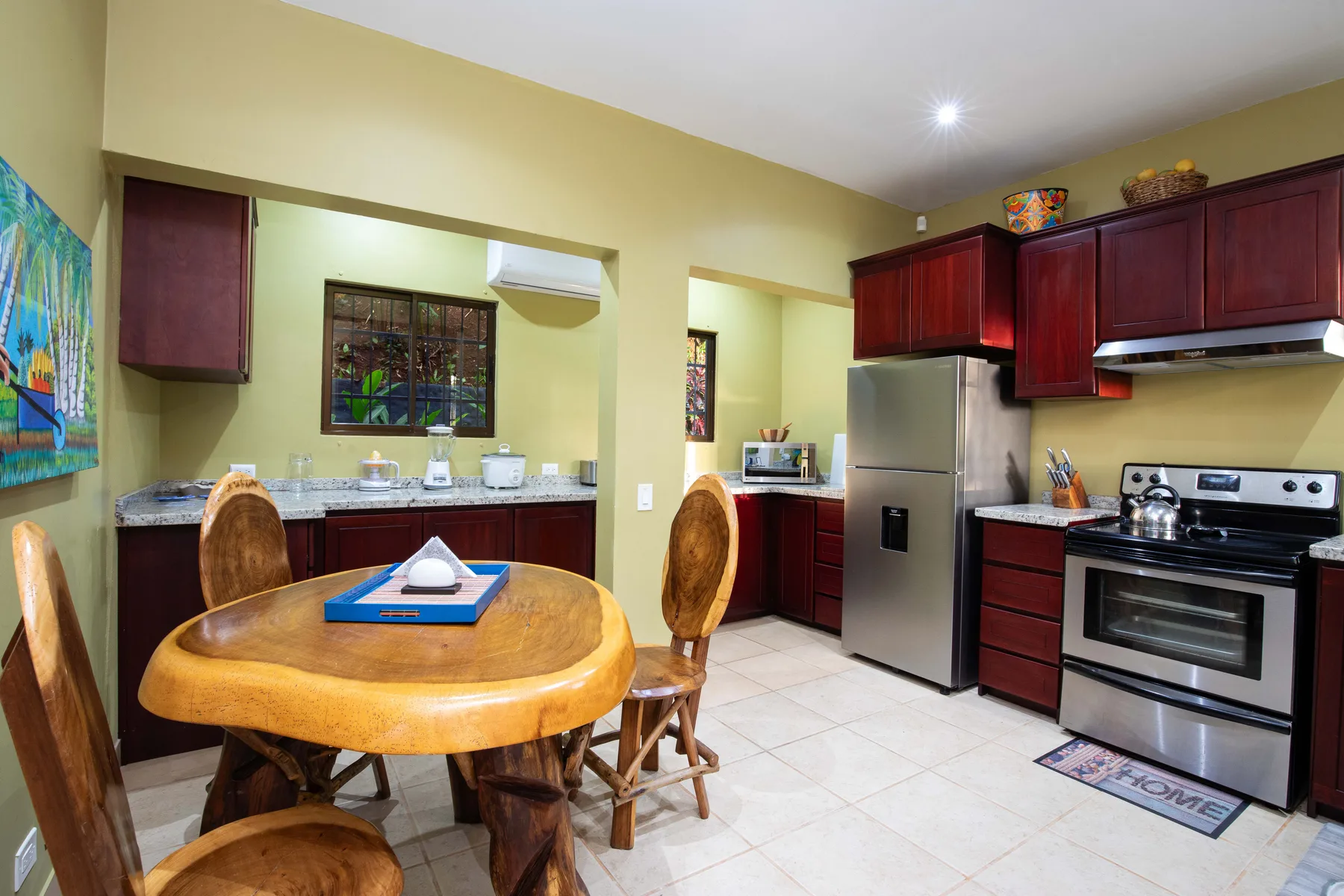 A kitchen and dining area with a round wooden table and stainless steel appliances.