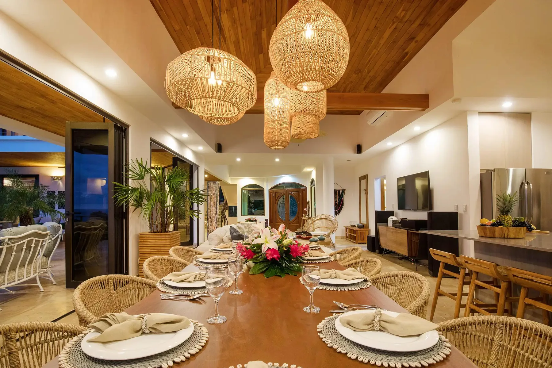 A dining area with a long table set with plates and a floral centerpiece.