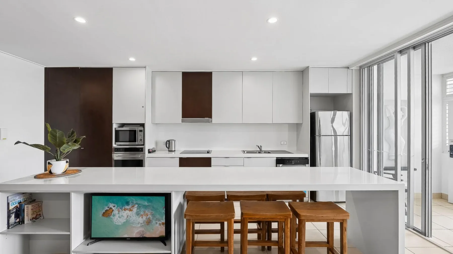 Una cocina moderna con una isla amplia y taburetes de madera.