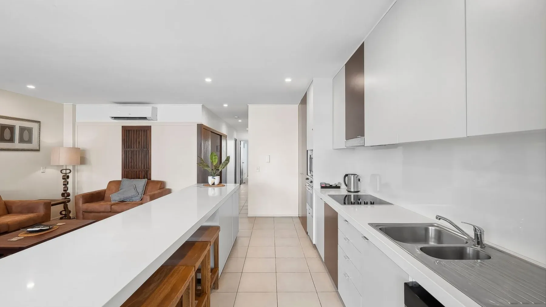 Una luminosa cocina abierta a la sala, con una barra larga y asientos.