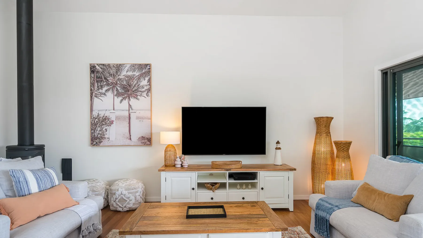 A living room with seating, a television, and a low wooden table.