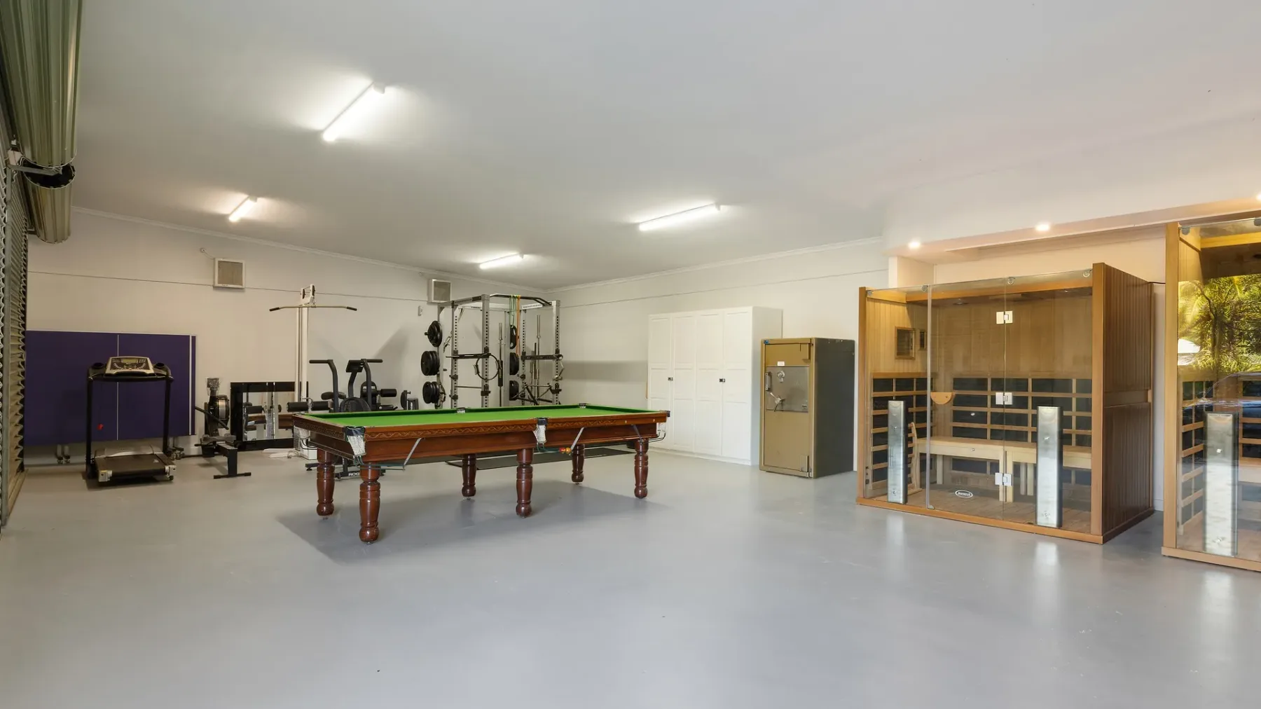 Una sala de recreación con una mesa de billar y equipo de ejercicio.