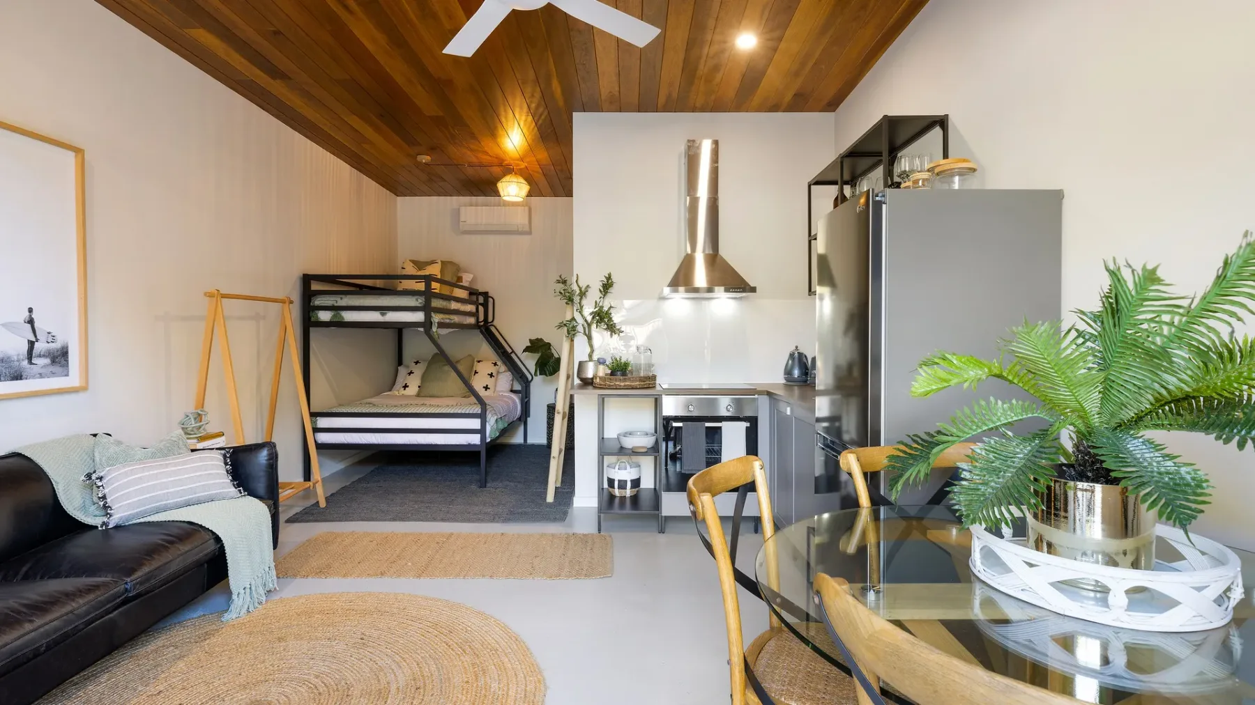 Un estudio compacto combina una pequeña cocina, una cama litera y un comedor.