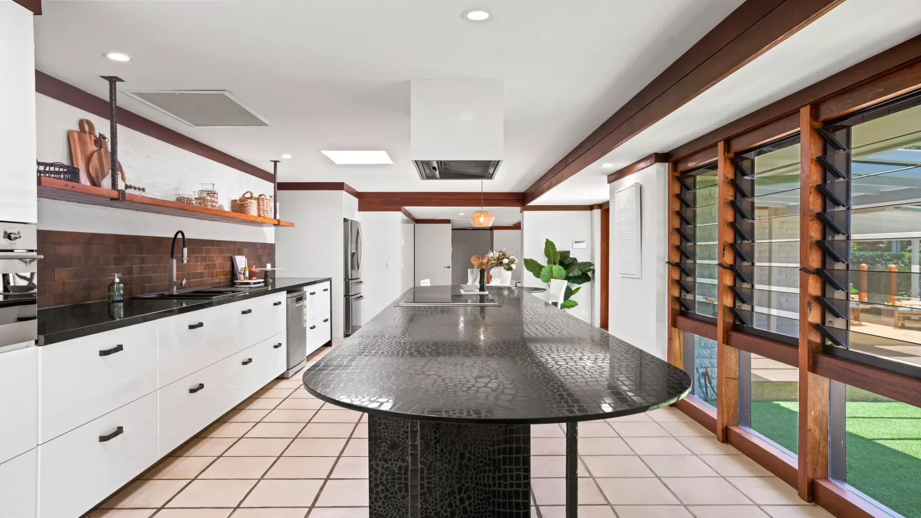 Una cocina moderna con gabinetes blancos y una isla grande.