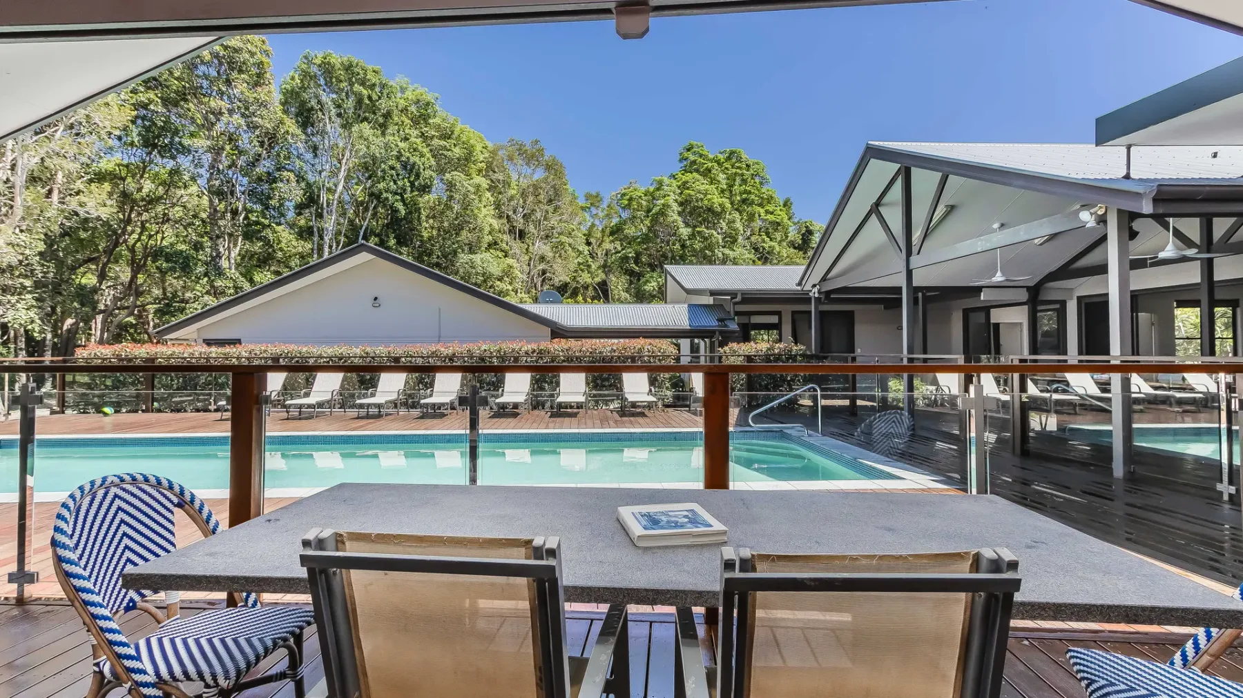 A poolside deck with outdoor seating overlooks a swimming pool.