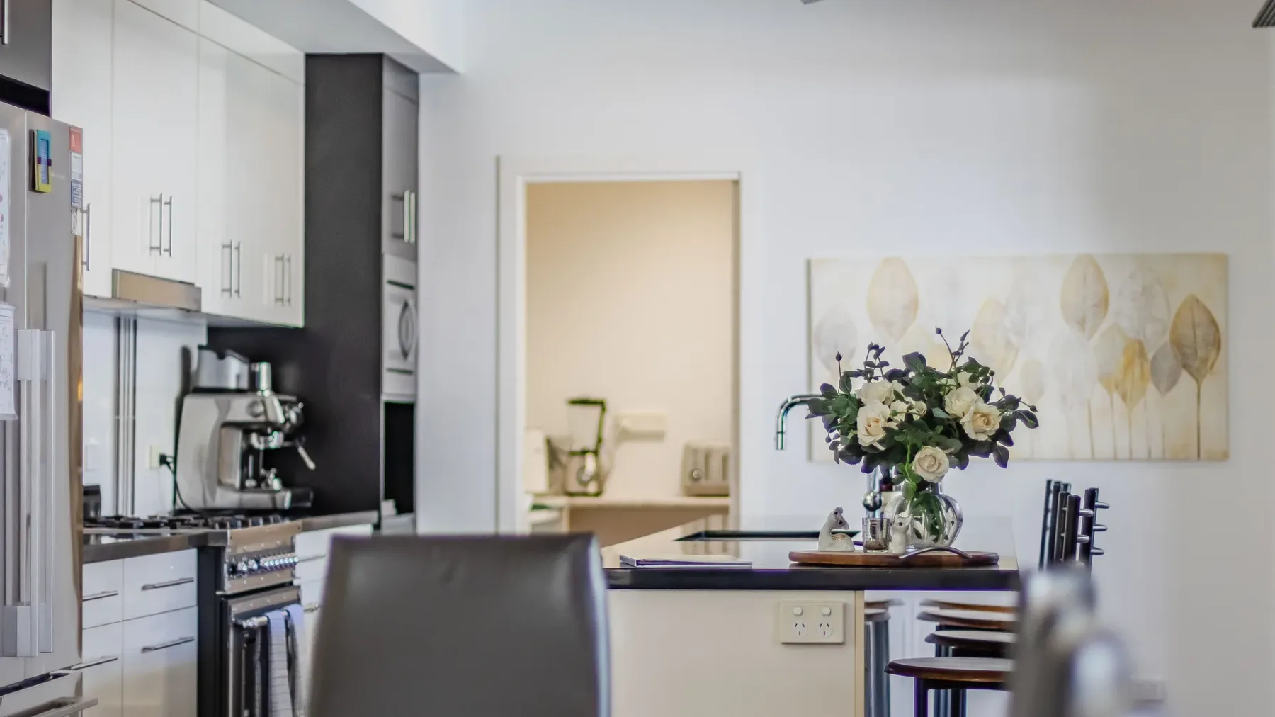 An open kitchen and dining area with a flower arrangement on the table.