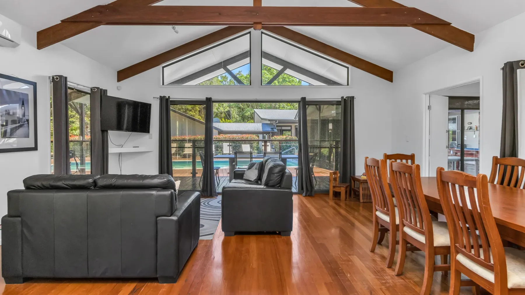 A living and dining room opens onto a patio through wide glass doors.