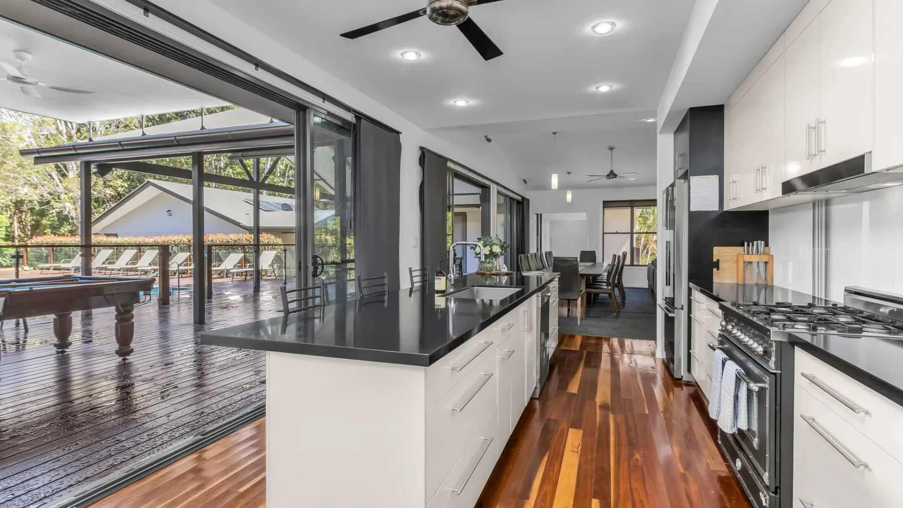 A modern kitchen opens onto a covered patio through wide glass doors.