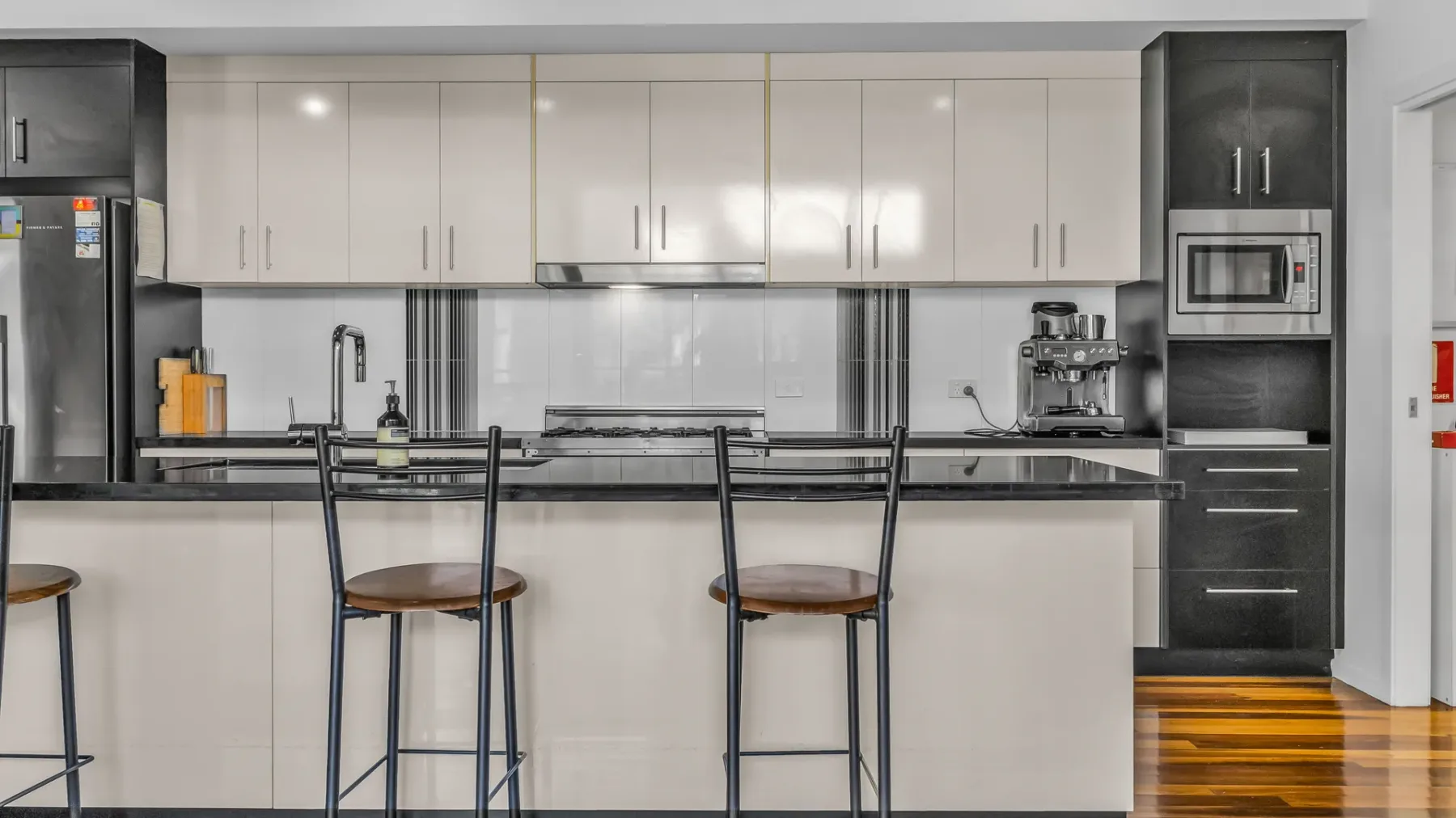 A modern kitchen with a long counter and bar seating.