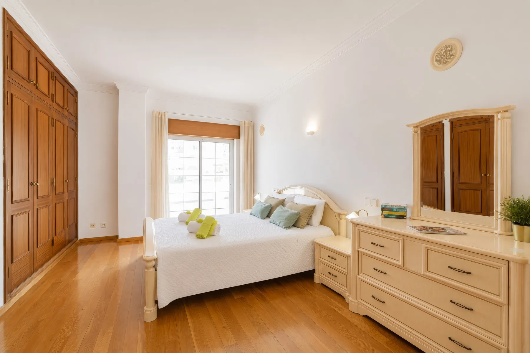 Un dormitorio con una cama, armarios de madera y una cómoda.