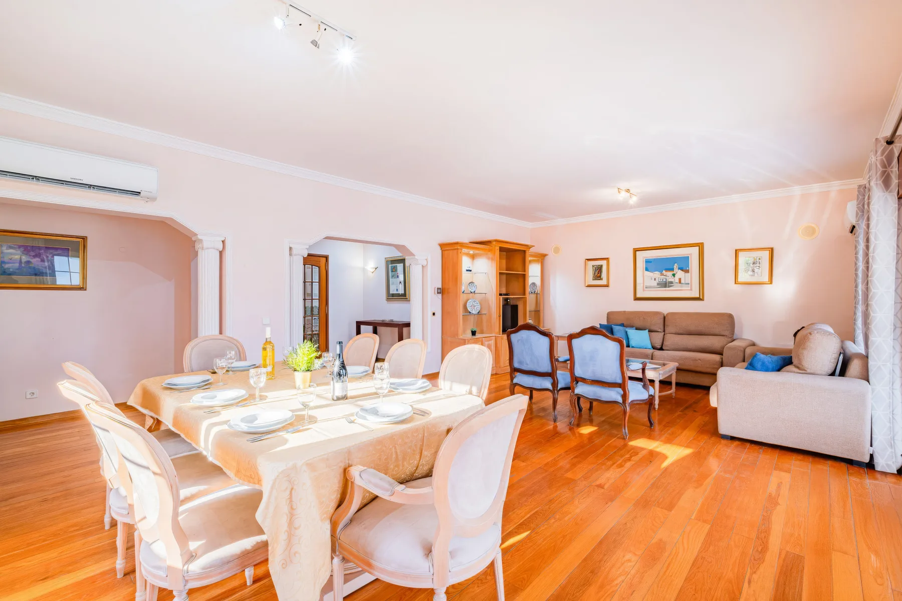 Un comedor y sala de estar con una mesa puesta y una zona de asientos.