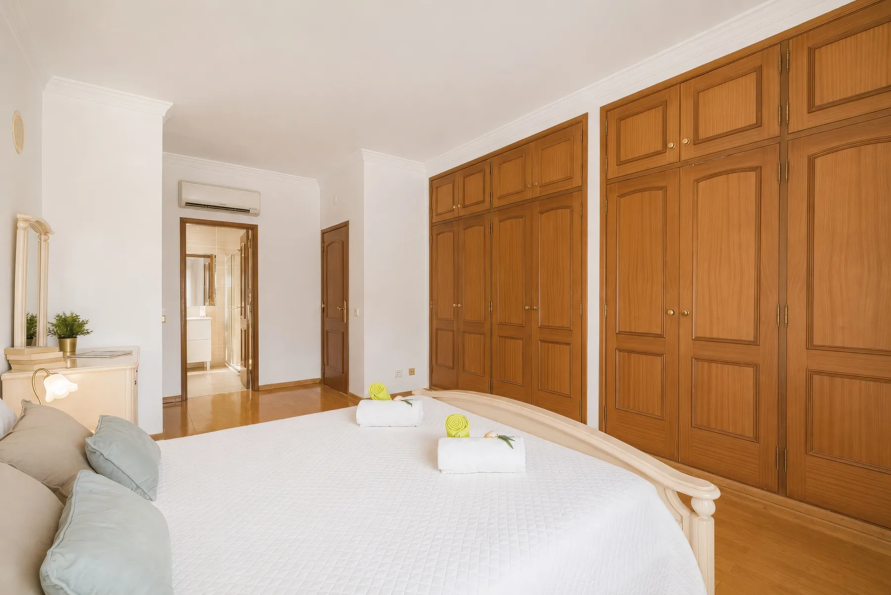 Un dormitorio con una cama y armarios de madera junto a la pared.