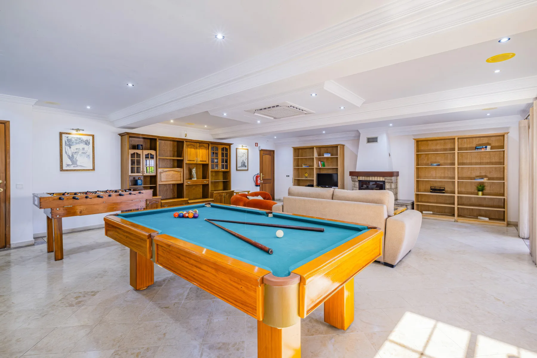 Una sala de recreación tiene una mesa de billar y una mesa de futbolín.