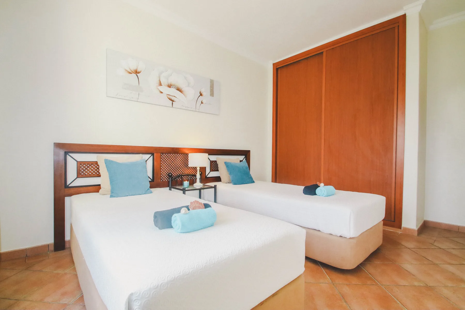 Un dormitorio con dos camas y un armario de madera.