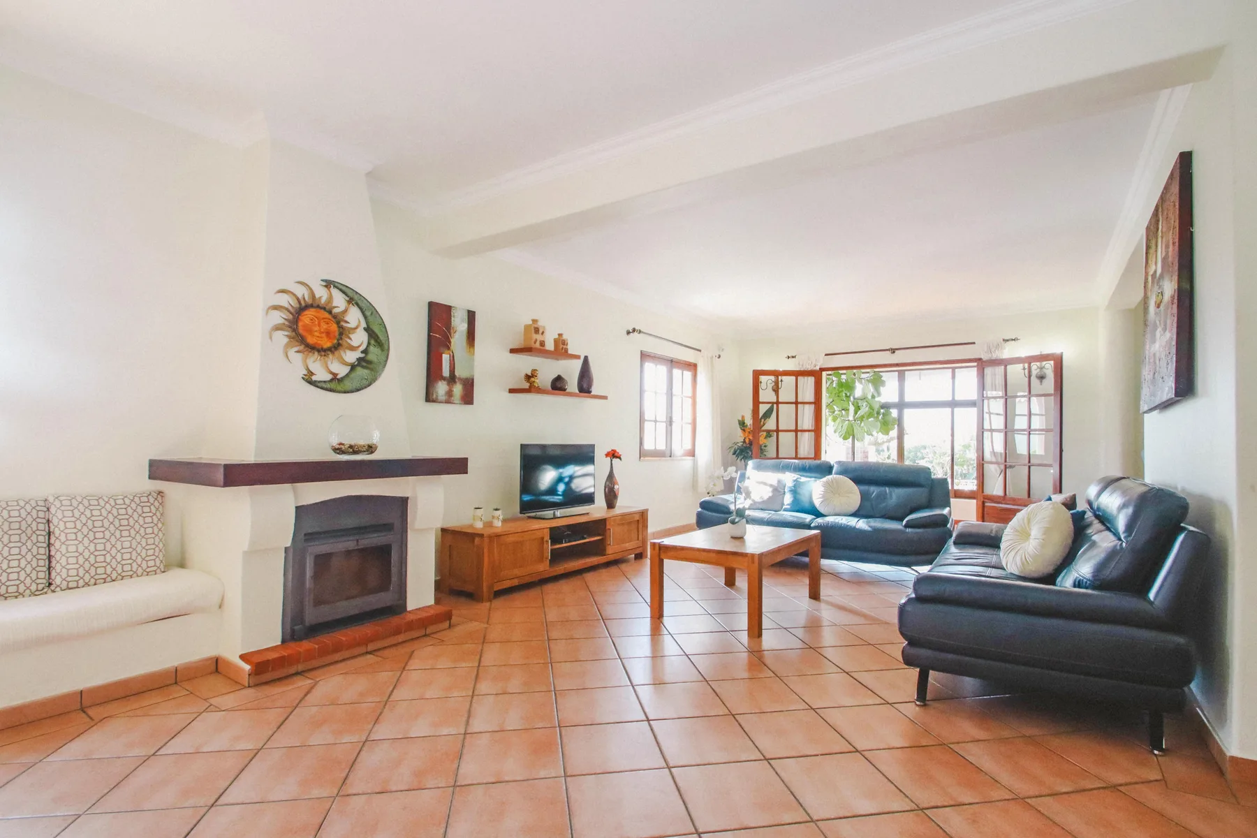 Una luminosa sala de estar con asientos, televisor y chimenea.