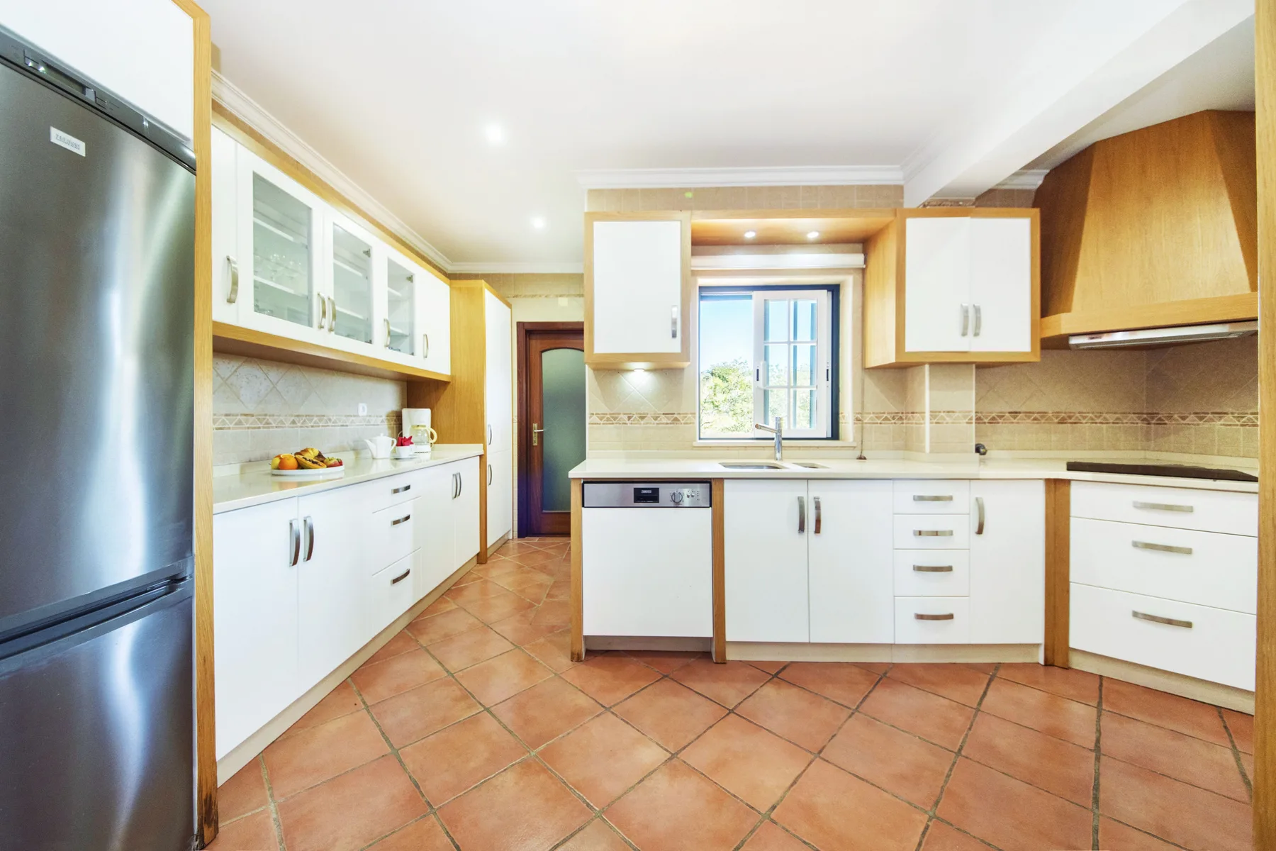 A bright kitchen with white cabinets and a window above the sink.