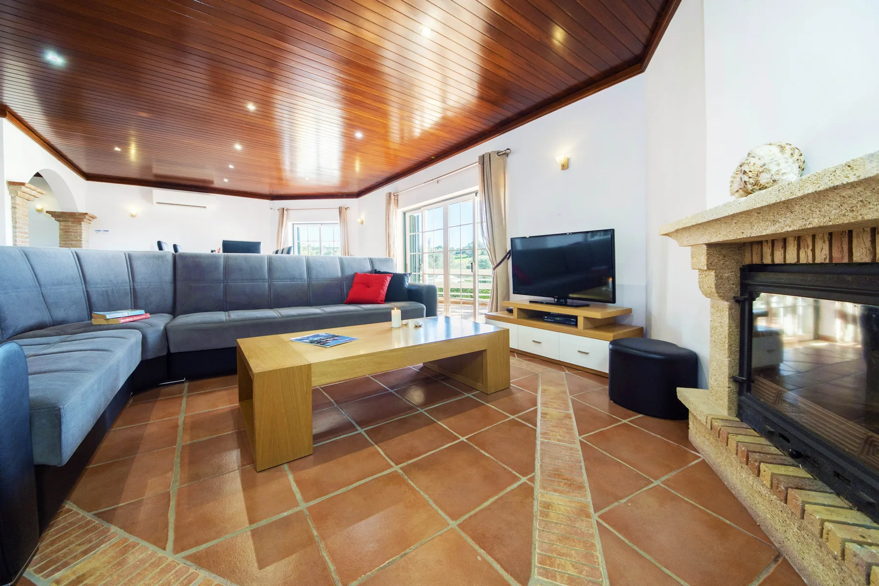 A living room with sectional seating, a coffee table, and a fireplace.