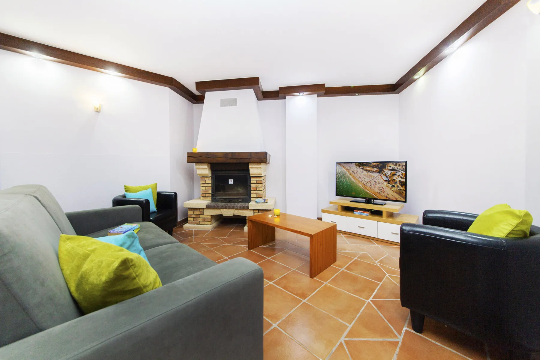A living room with seating arranged around a fireplace and television.