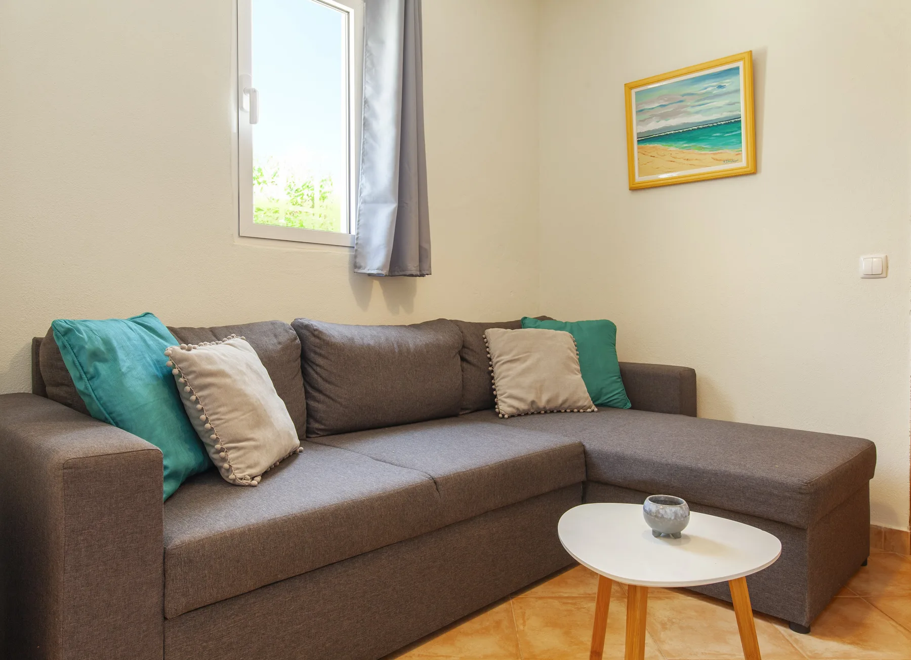 A living room with a corner sofa and a small coffee table.