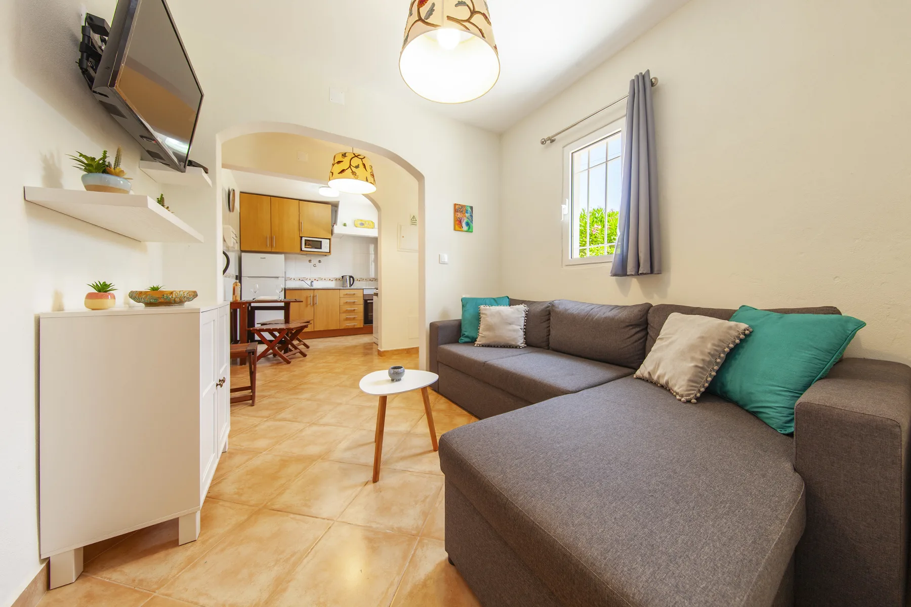 A living room with a sectional sofa and an open view into the kitchen.