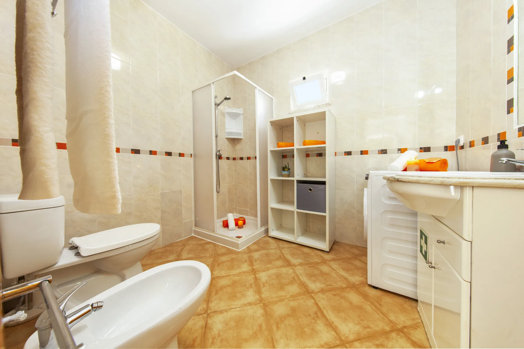 A tiled bathroom with a shower, bathtub, toilet, and sink.