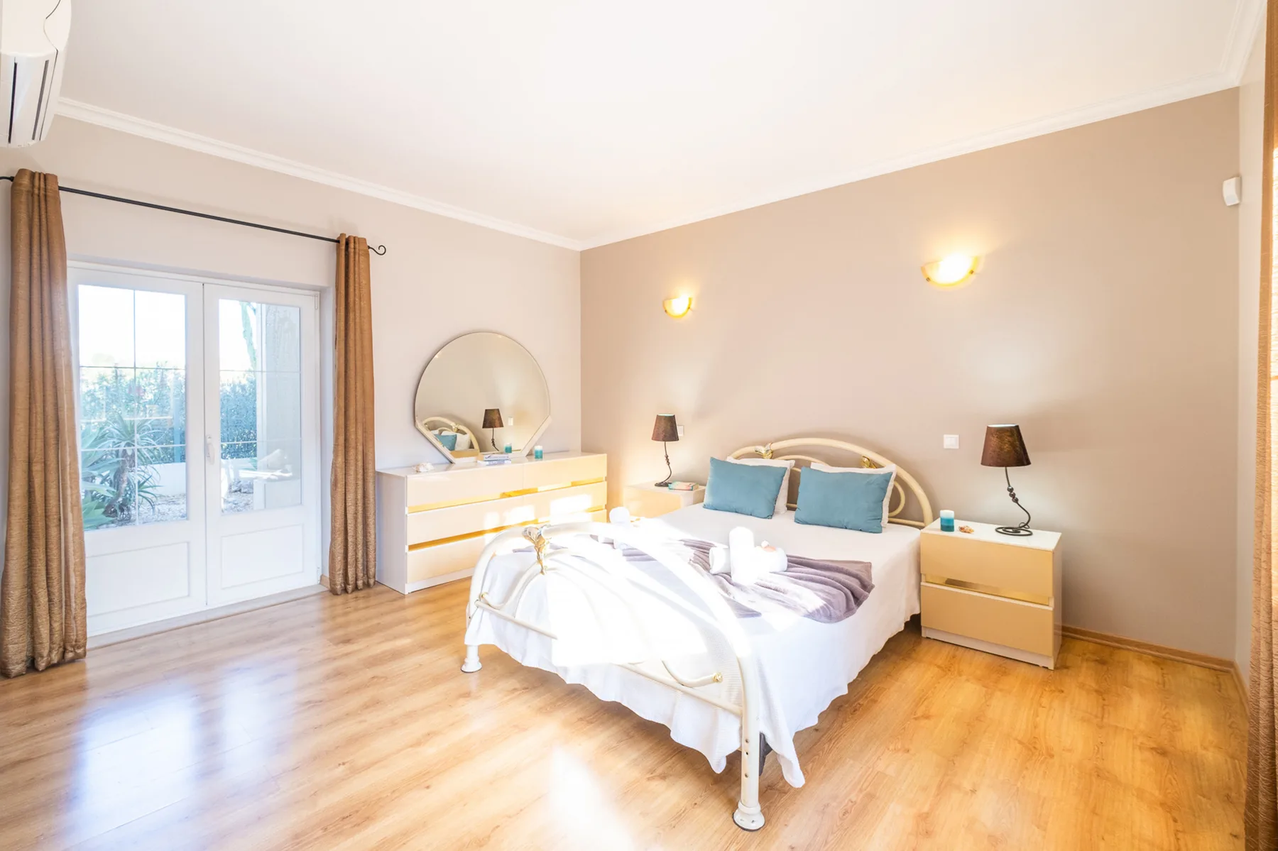 Un dormitorio luminoso con una cama, mesitas de noche y una cómoda.