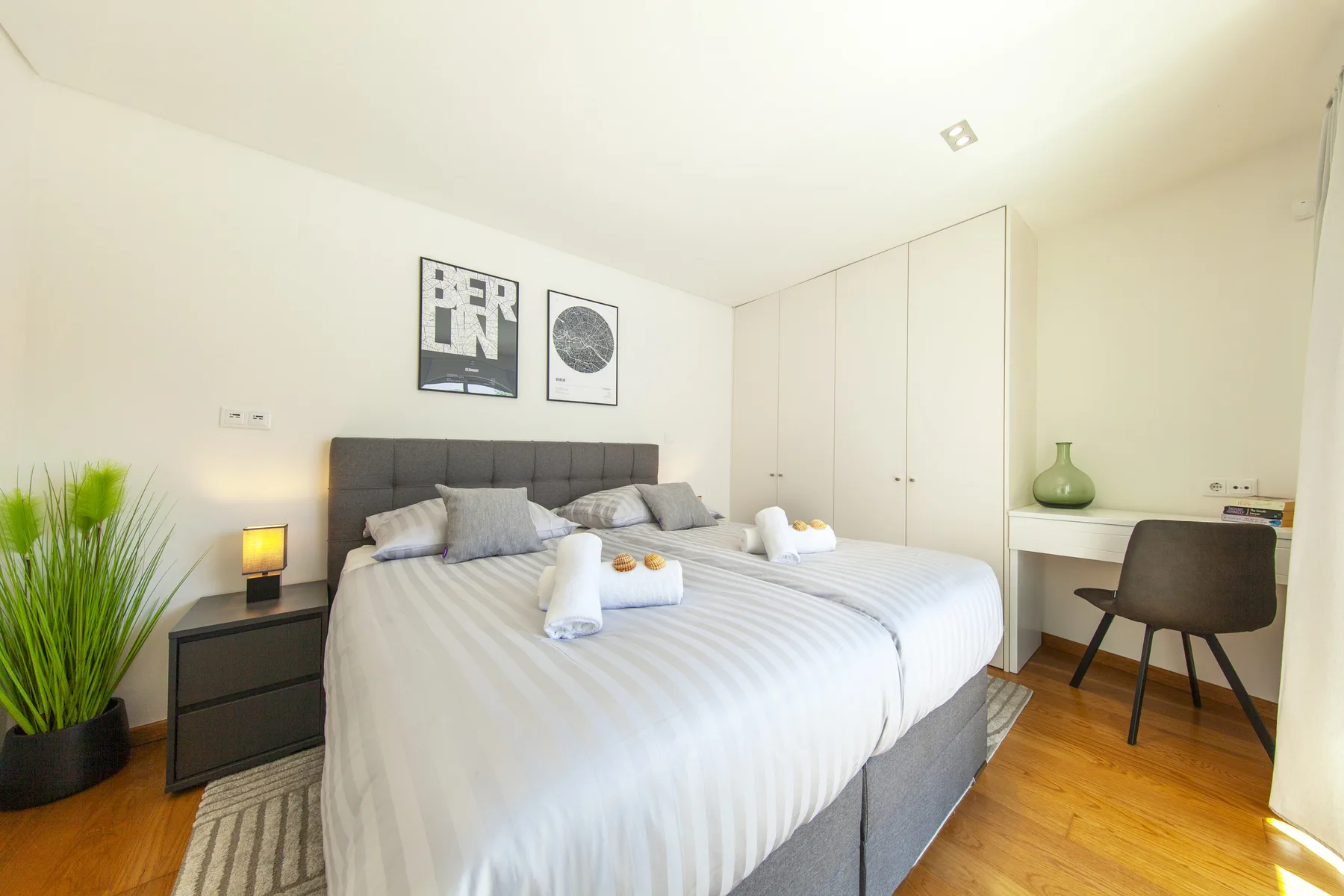 Dormitorio con una cama grande, mesitas de noche y un escritorio.