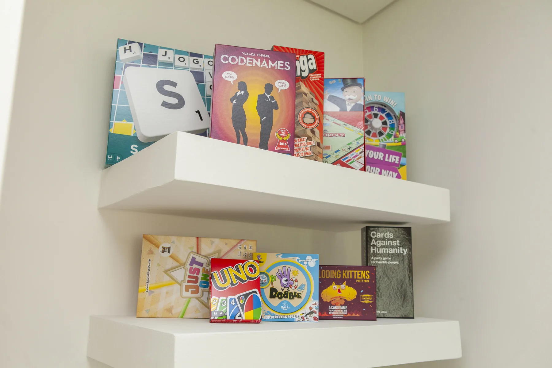 Un estante de pared exhibe una colección de juegos de mesa.