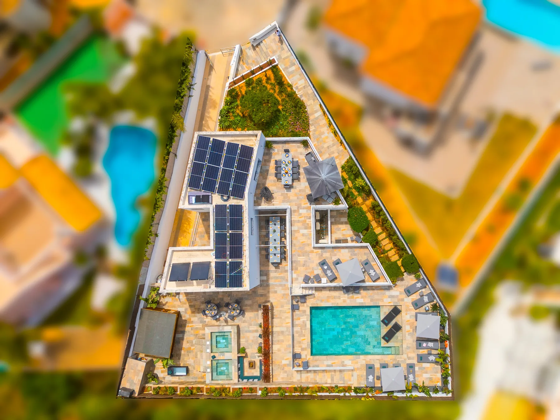 Vista aérea de una terraza en la azotea con piscina y paneles solares.
