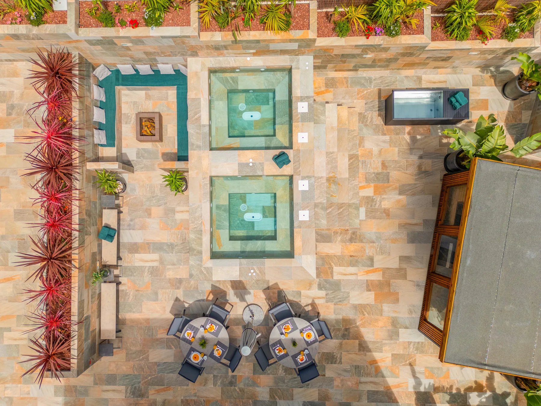 Un patio exterior con dos fuentes cuadradas y asientos.
