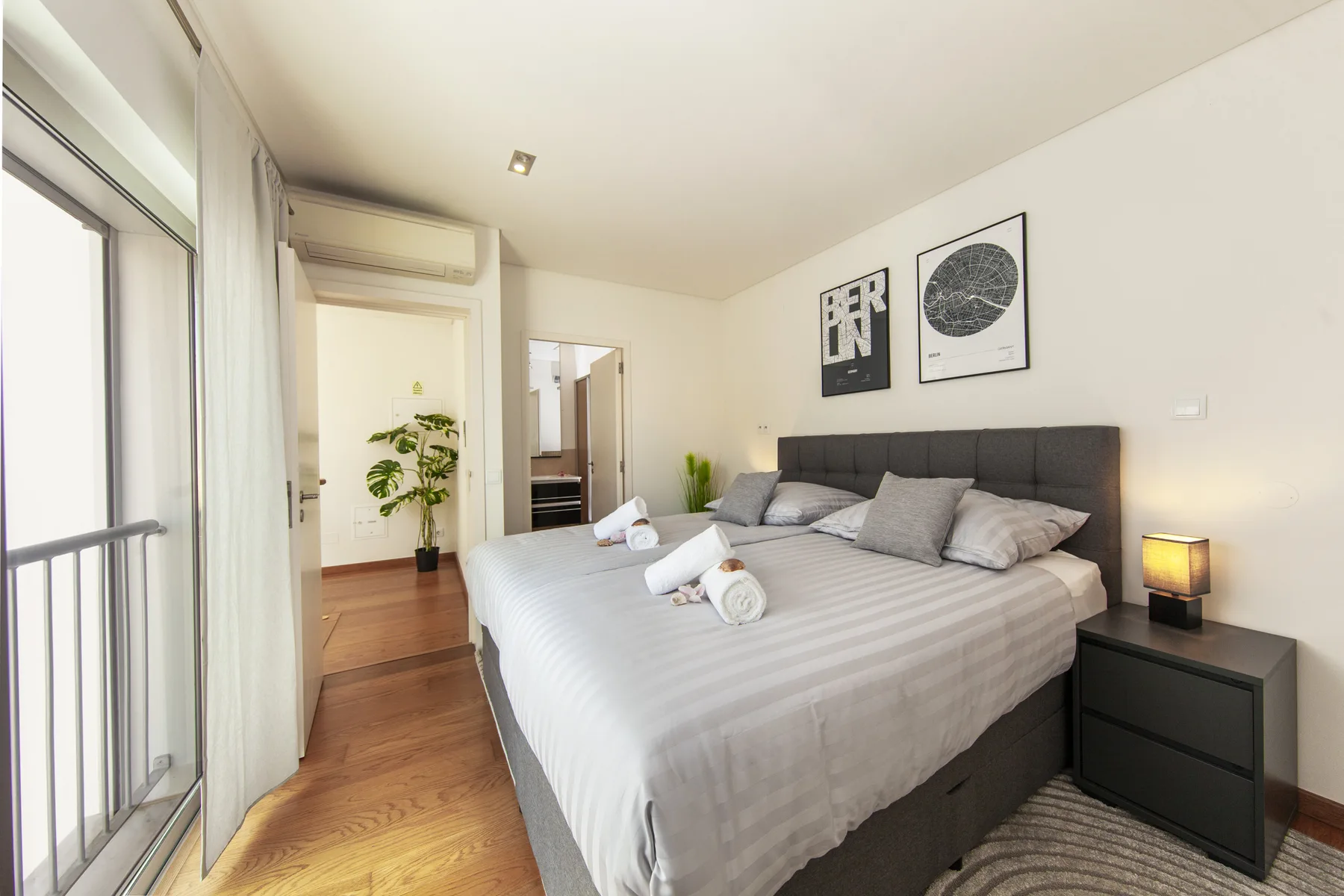 Un dormitorio luminoso con una cama grande y una puerta corrediza de vidrio.