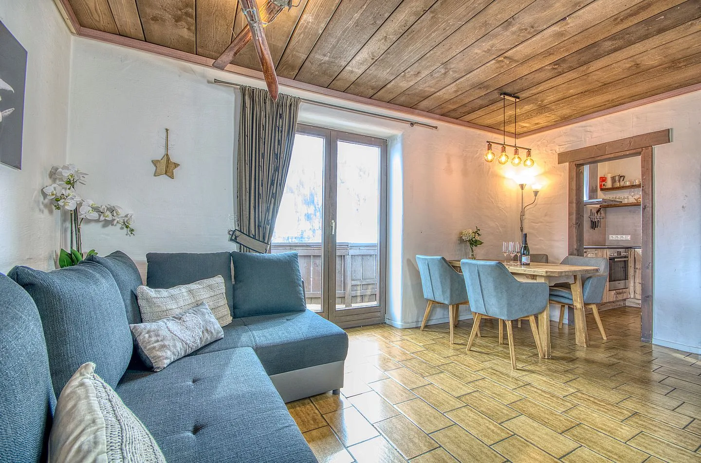 Una sala de estar y comedor con asientos azules y una mesa de madera.