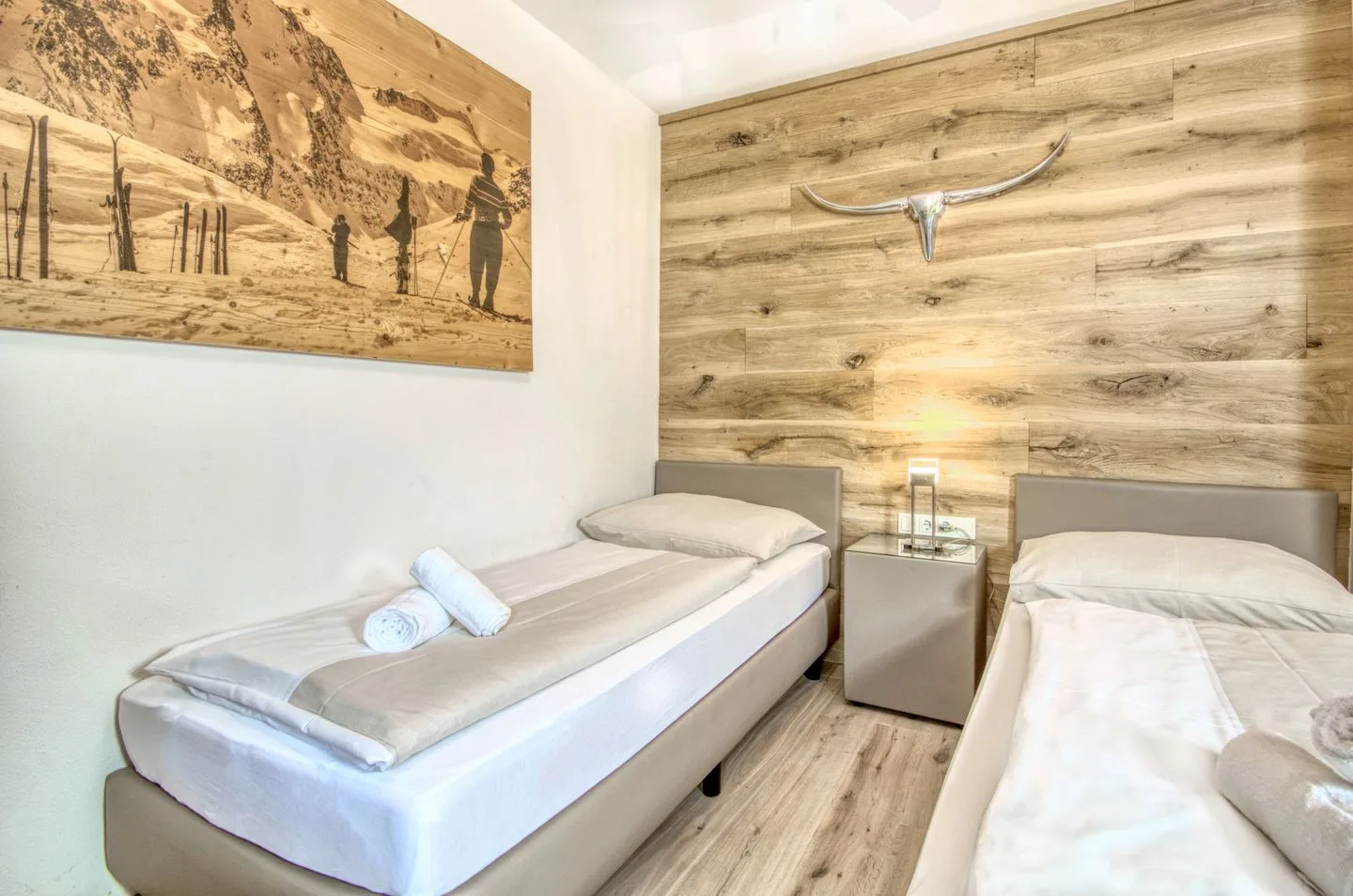 Un dormitorio con dos camas y una pared revestida de madera.