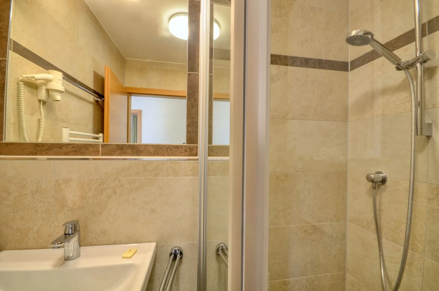 Un baño con azulejos, lavabo y ducha.
