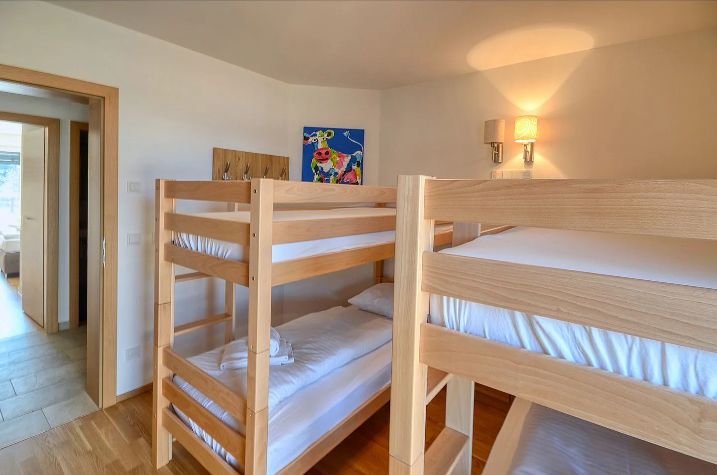 Un dormitorio con literas de madera y cuadros en la pared.