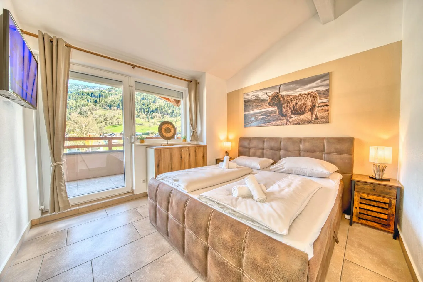 A bedroom with a bed beside glass doors opening onto a balcony.