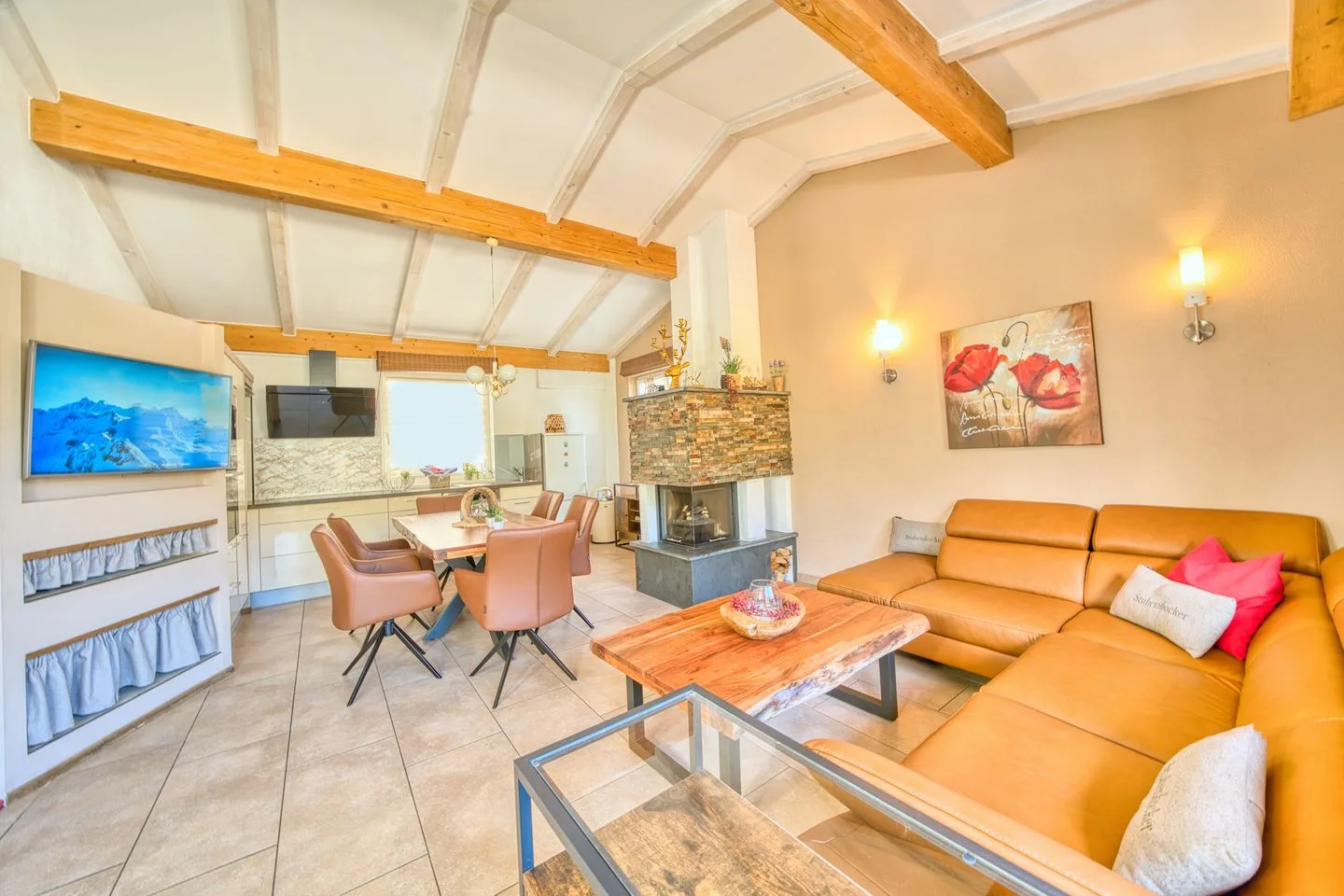 A living room with a sectional seating area and an open dining space.