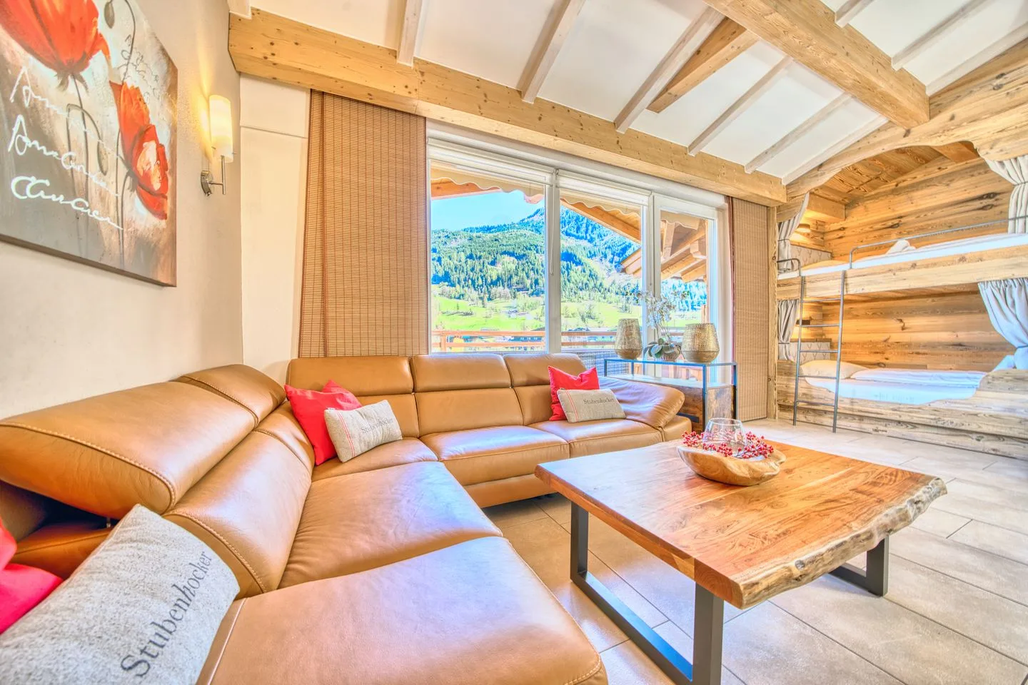 A bright living room with a sectional seating area and large windows overlooking a mountain landscape.