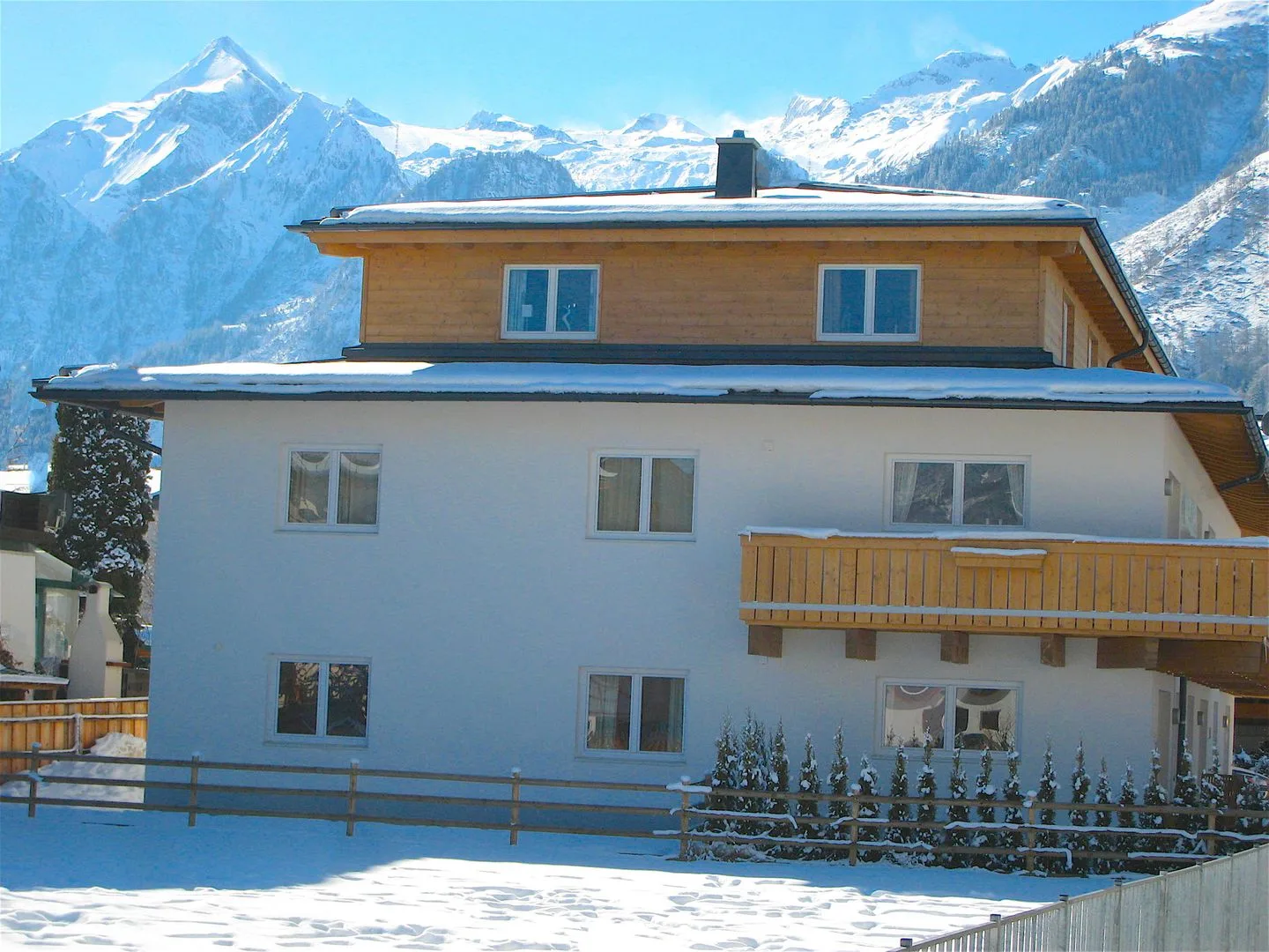 Zona común: Un edificio cubierto de nieve se alza frente a las montañas.