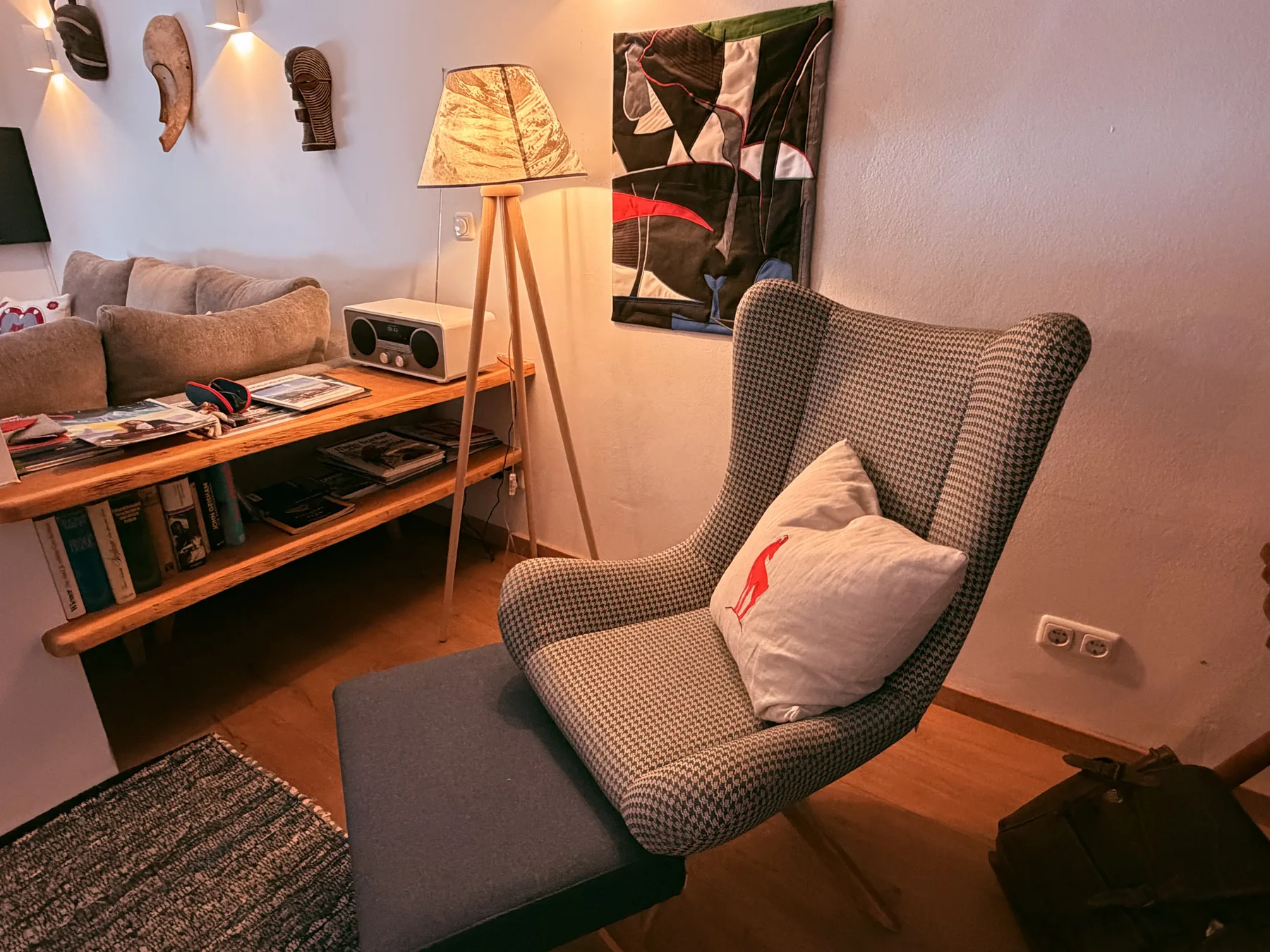 A warmly lit living room with seating, a wooden coffee table, and a floor lamp.