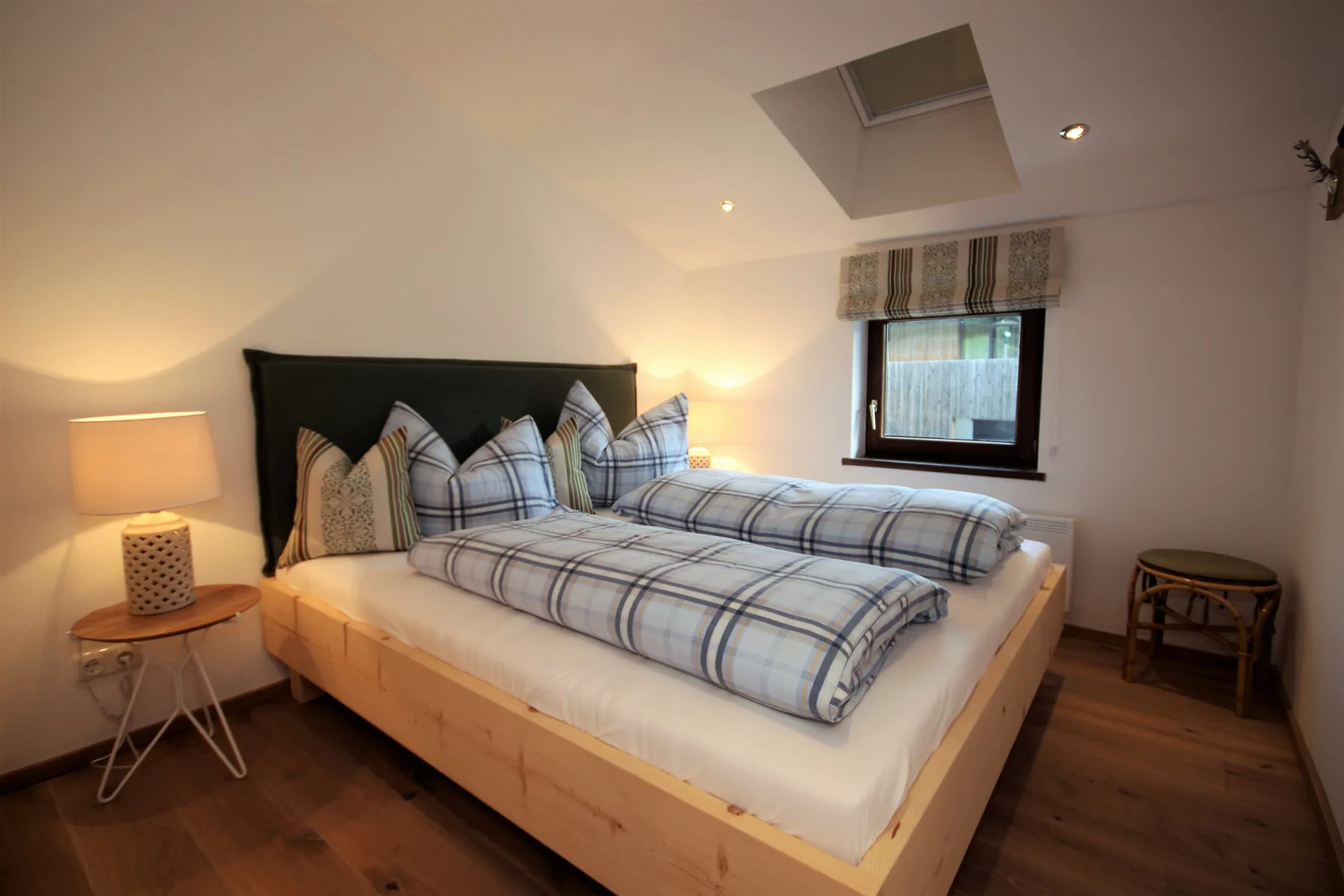 A bedroom with a large bed dressed in blue-and-white plaid bedding.