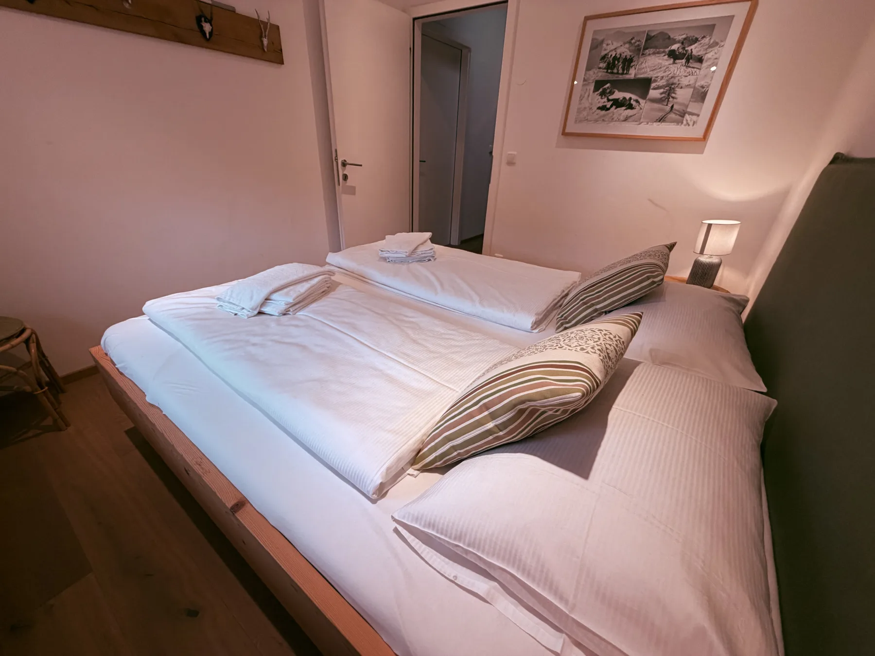 A bedroom with a neatly made bed and striped decorative pillows.