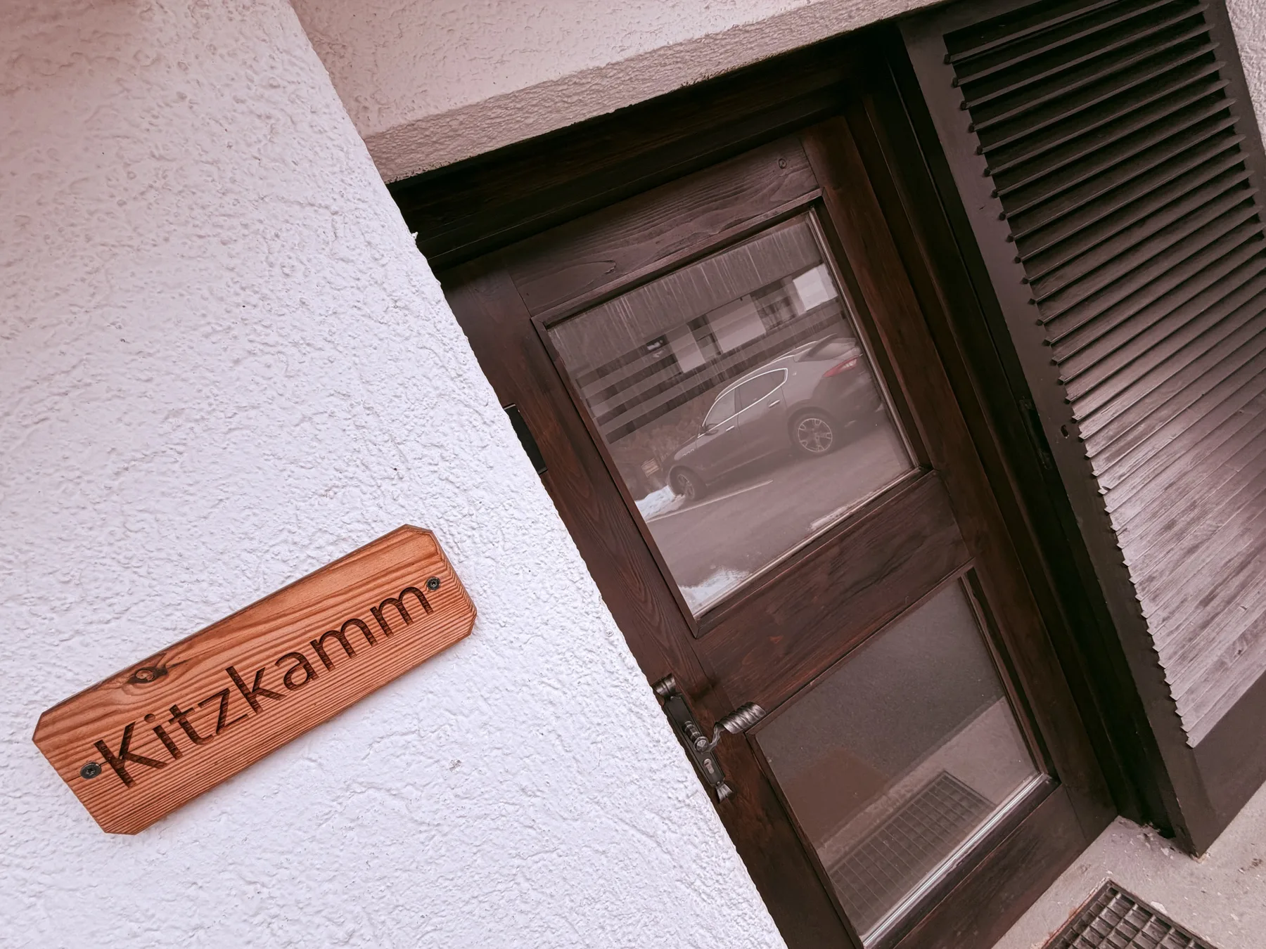 Shared amenity: A wooden door with glass panels beside a small name plaque.