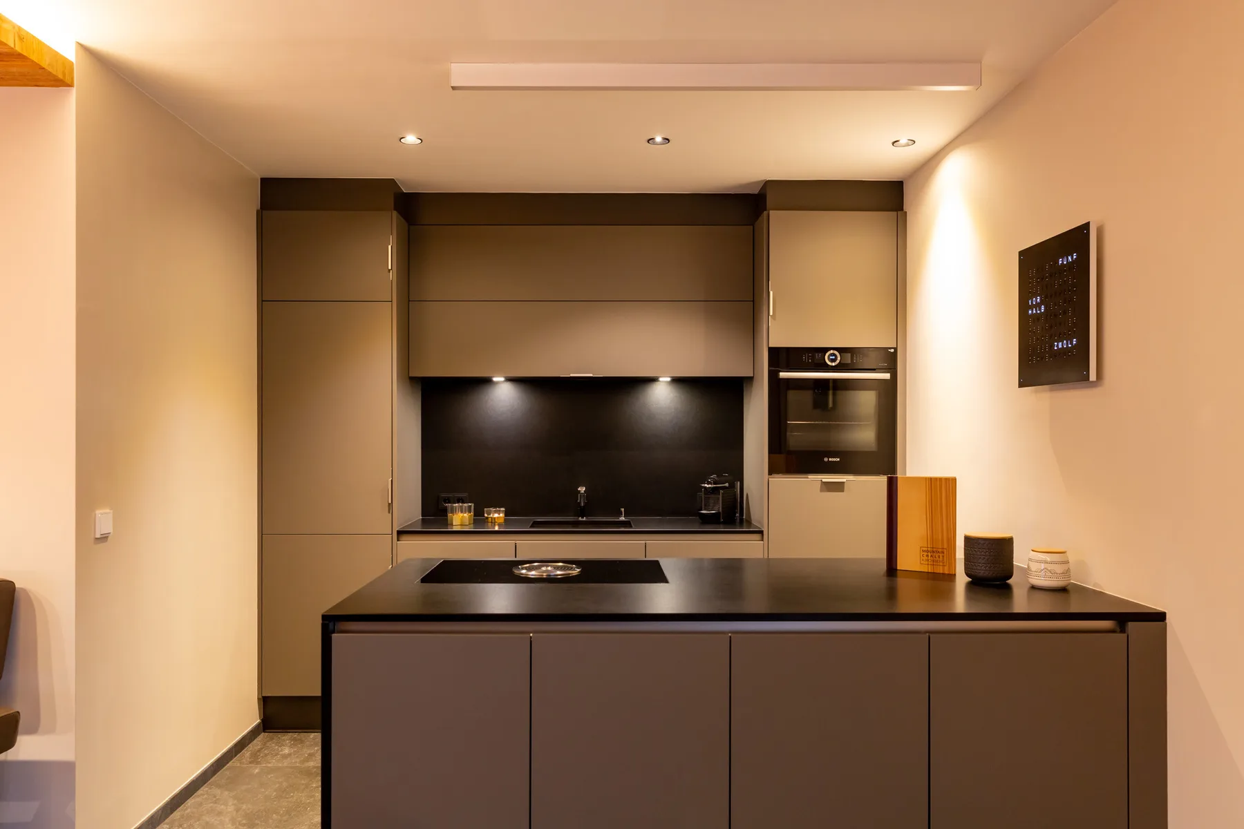 A modern kitchen with dark cabinetry and a central island.