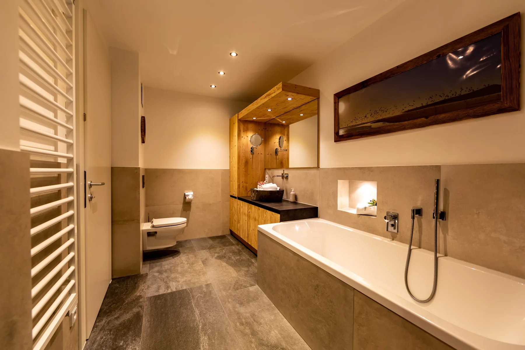 A spacious bathroom with a bathtub, walk-in shower area, and wooden vanity.