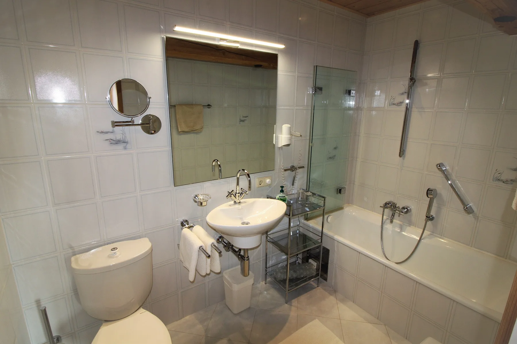 A tiled bathroom with a sink and bathtub.
