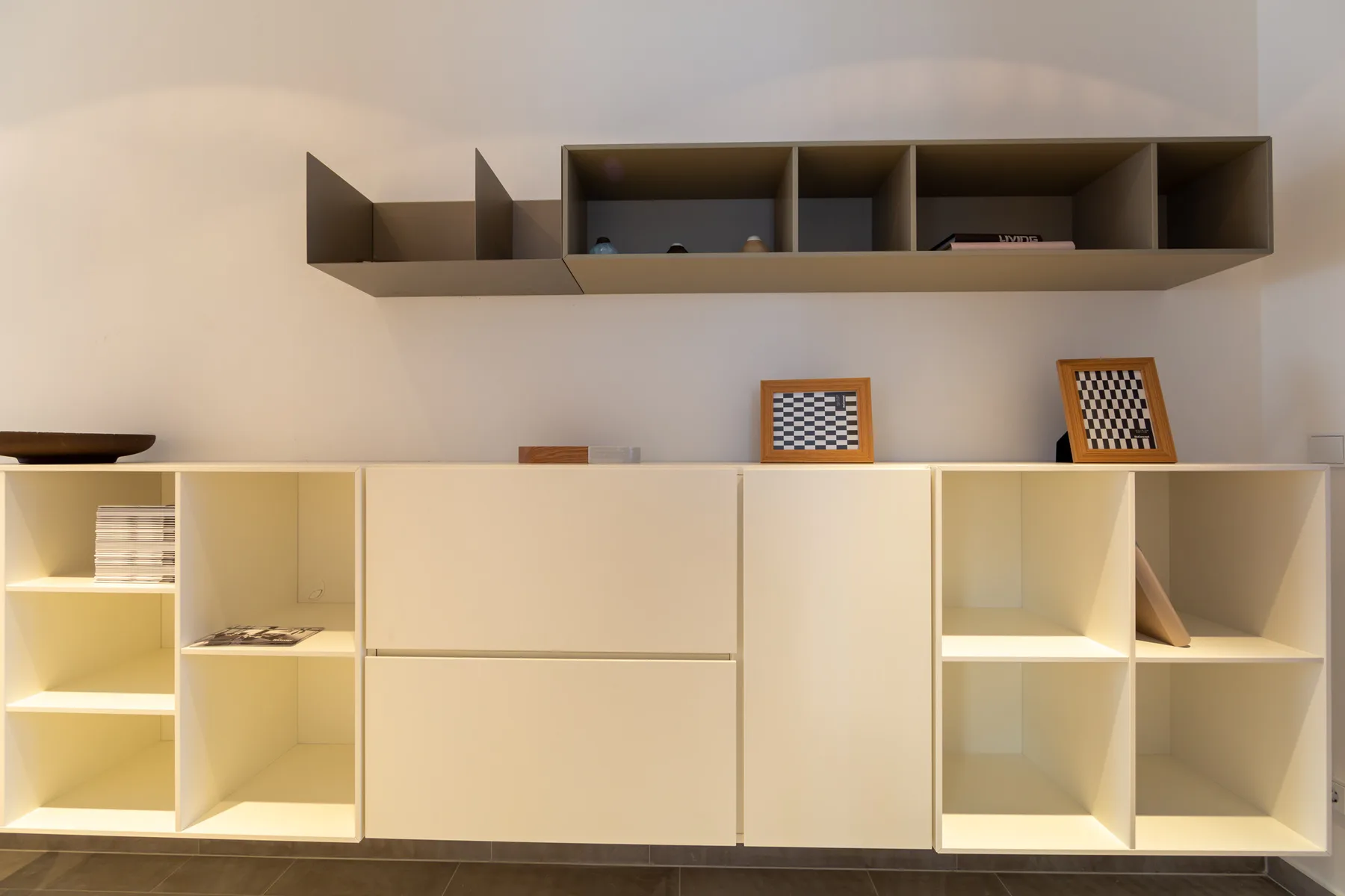 A bright room with built-in shelving and cabinets along the wall.