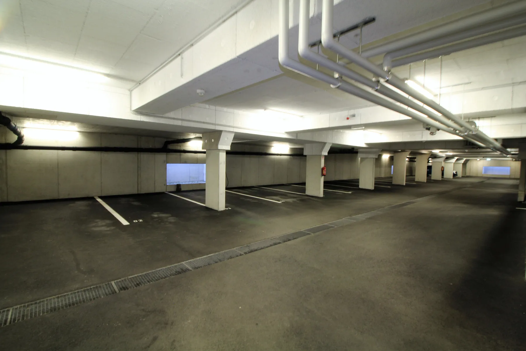 Shared amenity: Underground parking garage with marked parking spaces.