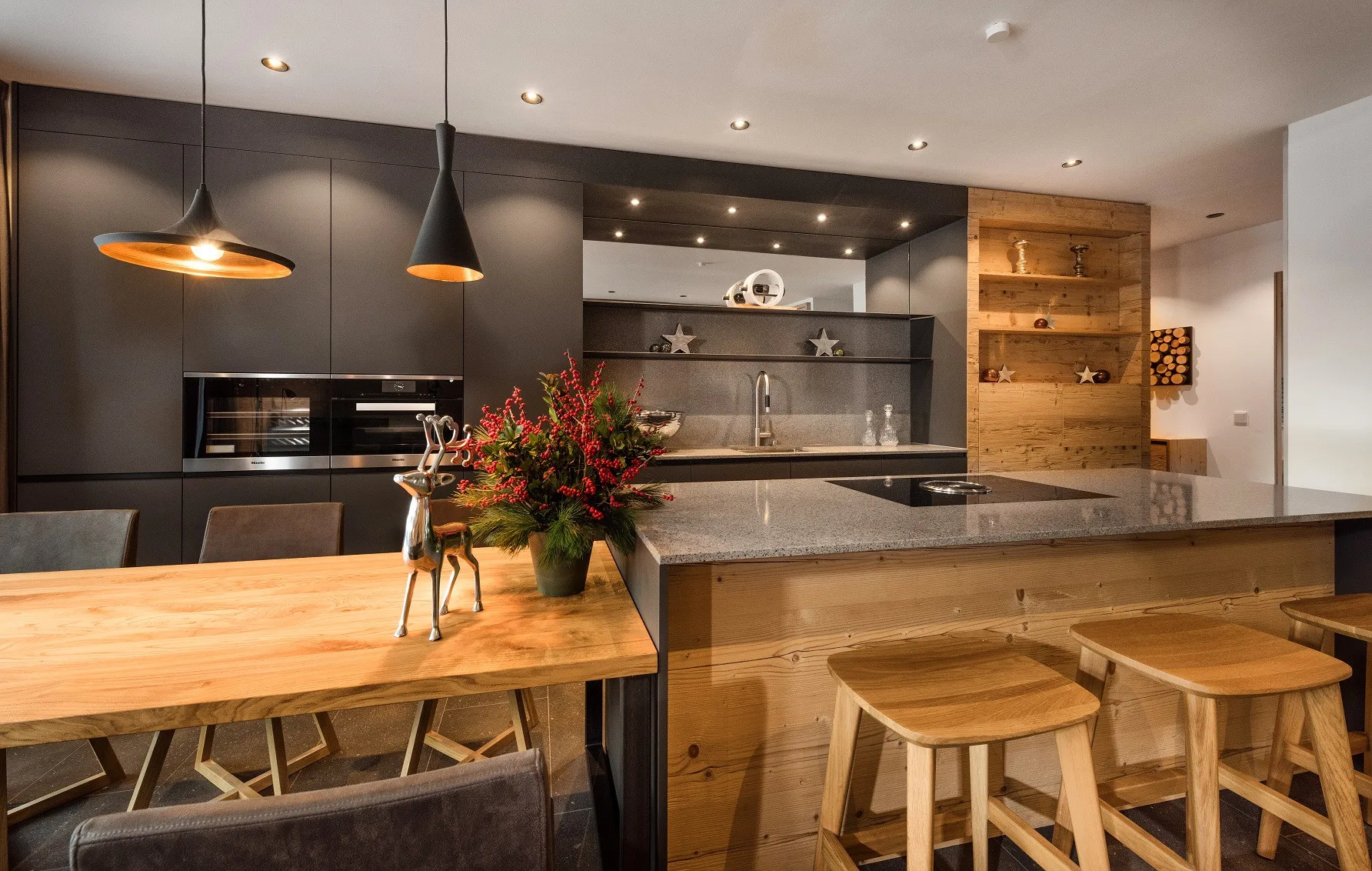 Una cocina moderna con una isla grande y una mesa de comedor de madera.