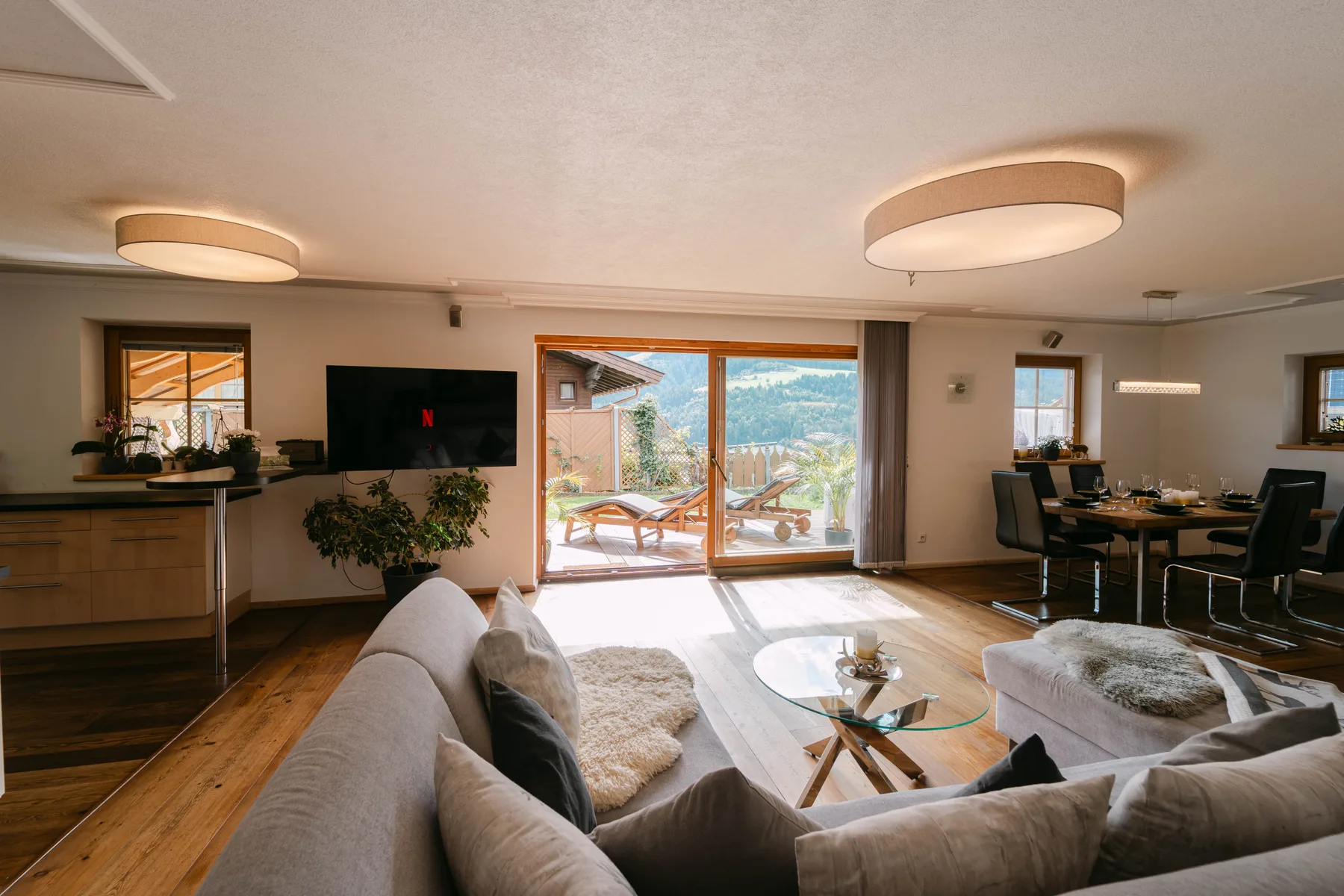 Una sala con comedor se abre a un patio mediante amplias puertas de vidrio.